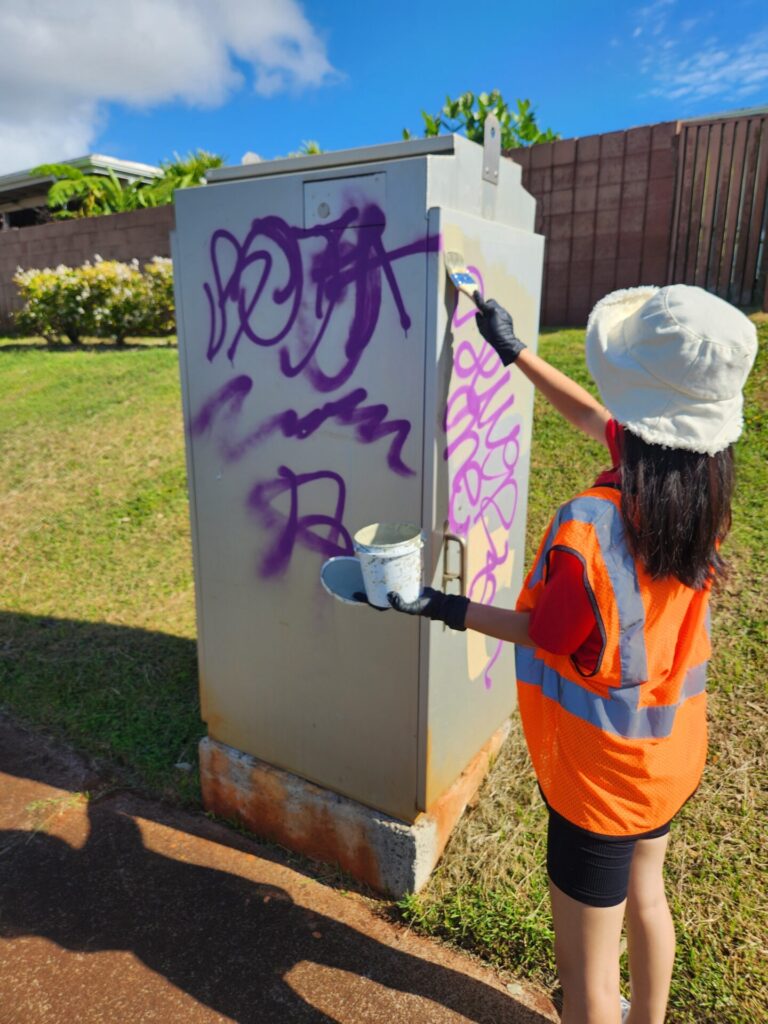 Community member painting over graffiti