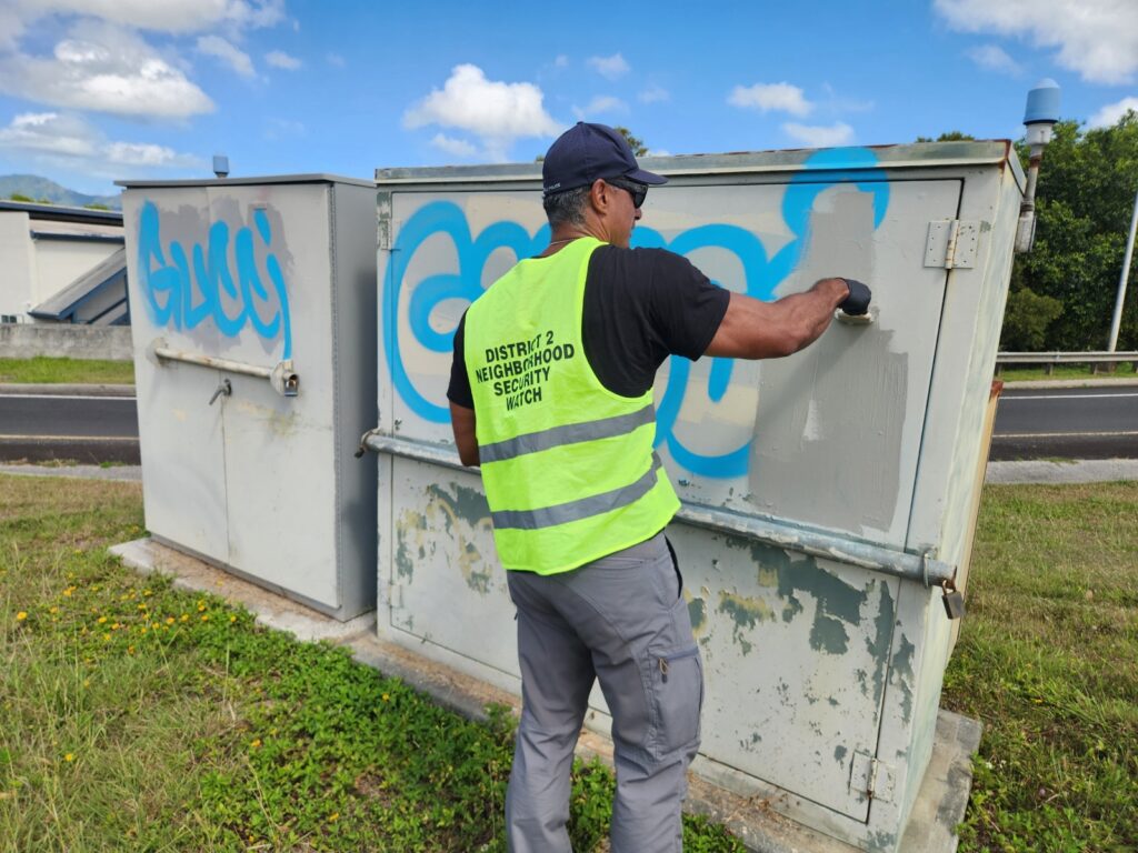 Officer painting over graffiti