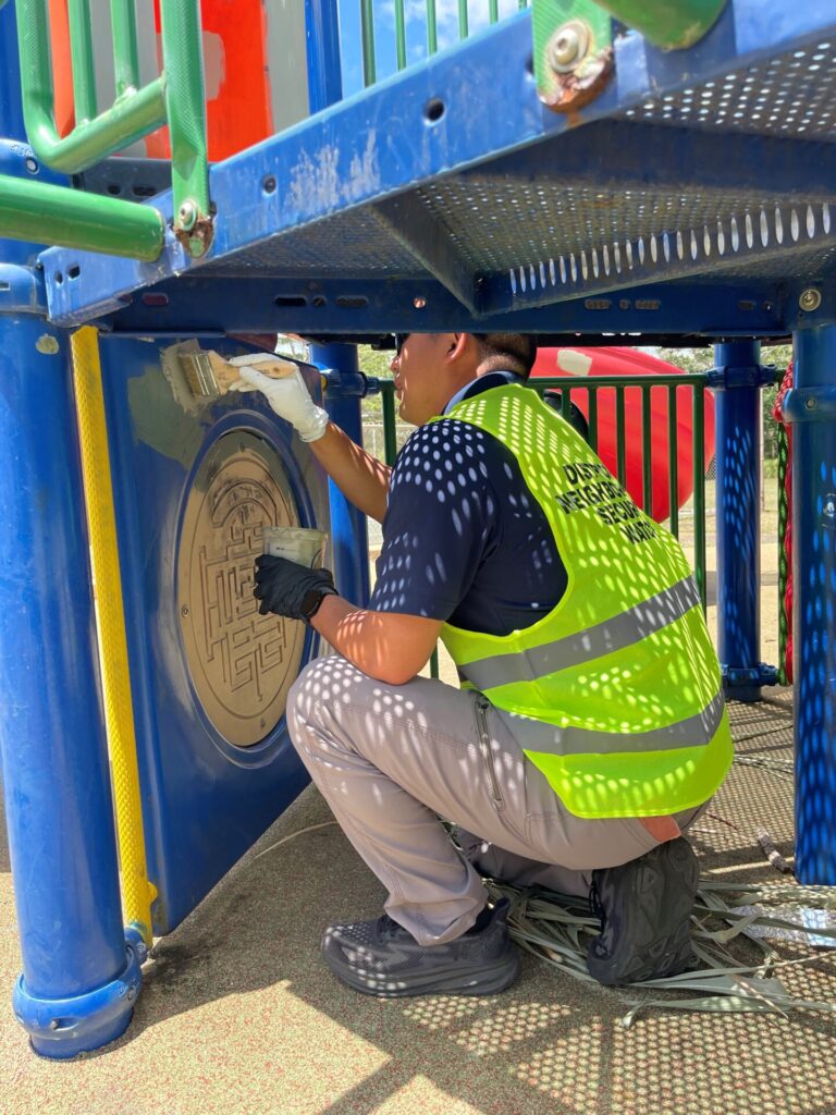 Officer paining over graffiti