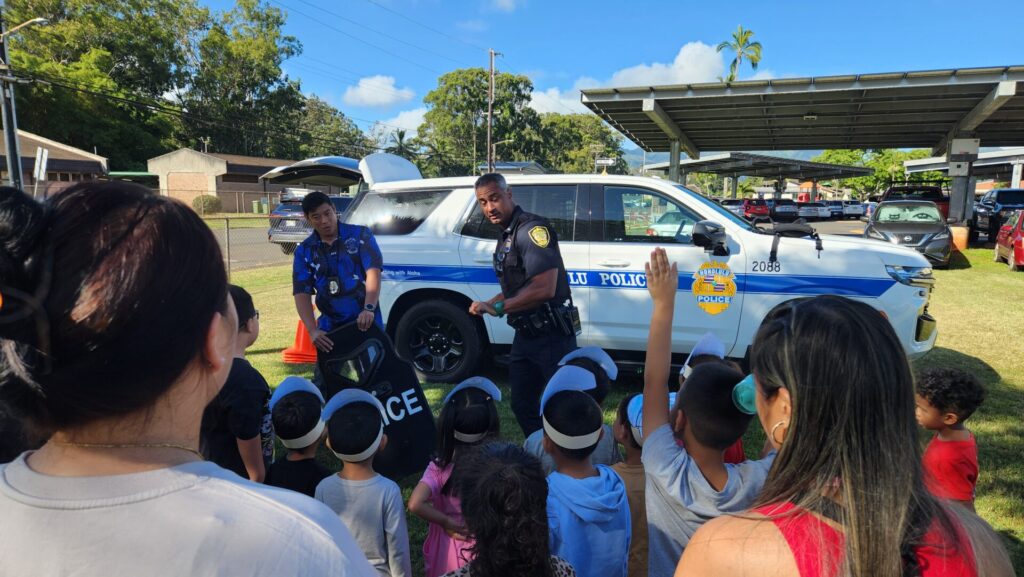 Officers informing students what police officers do in the community.