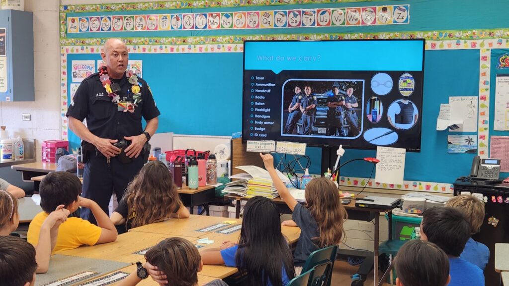 Officers talking to students about what police do in the community