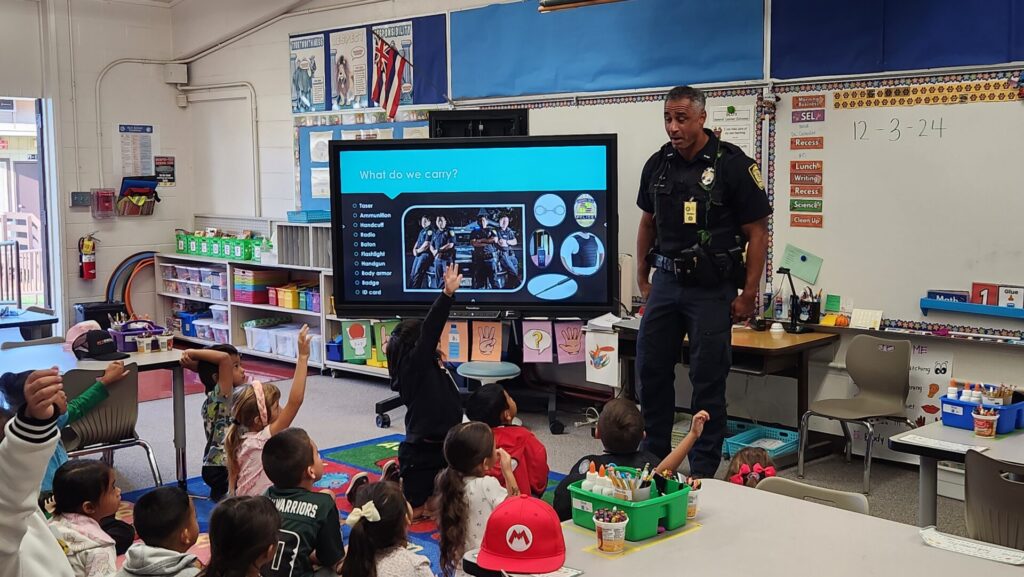 Officer educating students on what police do in the community